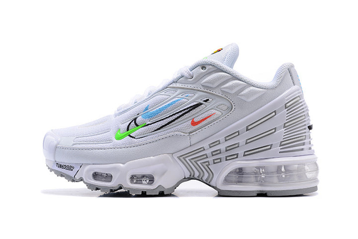 Side view of a white Nike kids' sneaker with colorful accents, geometric side detailing, and a clear heel cushioning unit.