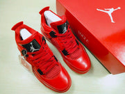 Pair of red high-top sneakers shown from an angled top view beside the presentation box.