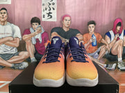 Front view of the Nike basketball sneakers showing orange textured toes, dark laces, and graphic tongue details.