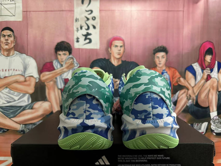Rear view of multicolor Adidas Adizero basketball shoes with green and blue camouflage panels and green outsoles.