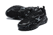 Pair of black and silver graphic sneakers shown at an angled top view.