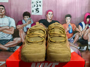Front view of wheat-toned Nike sneakers with textured uppers and lace-up closure