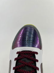 Top-down close-up of perforated iridescent purple toe panel and burgundy laces.