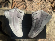 Overhead view of the pair placed on a black box, showing the side panels, collars, and outsoles.