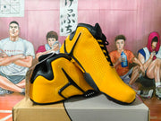 Pair of yellow and black high-top basketball sneakers shown from an angled side view on a box.