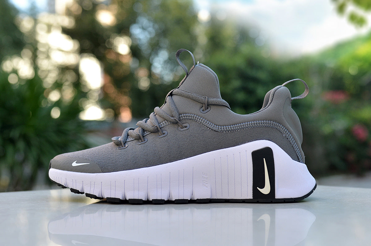 Gray Nike low-top sneaker with a white sole and black heel accent, shown from the side.