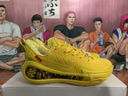 Side profile of a yellow basketball sneaker showing the lace-up upper, translucent side panel, and graphic midsole insert.