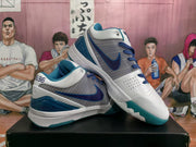 Angled product view showing the white and blue basketball sneakers, dark blue laces, side swoosh, and translucent teal outsole.