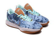 Three-quarter view of the pair showing the blue upper, pale aqua laces and lining, brown tongue details, and white midsoles.