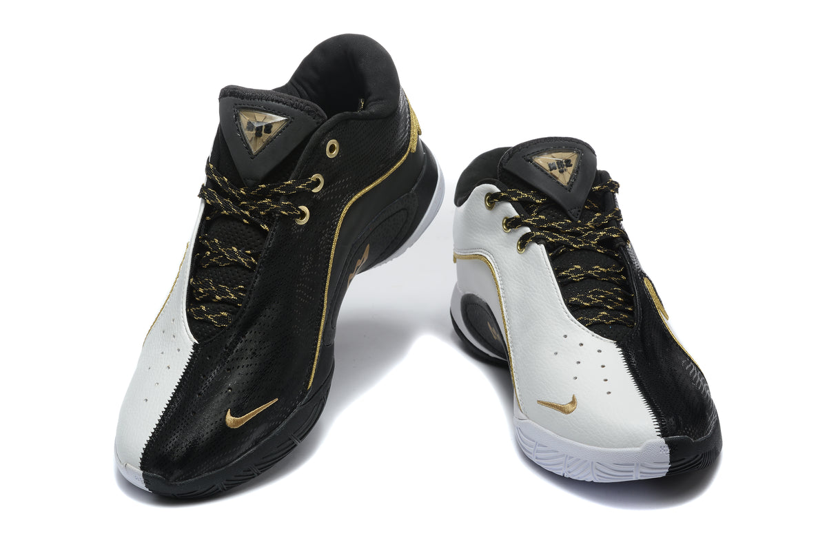 Pair of black and white Nike sneakers shown from the front with gold accents and patterned laces.