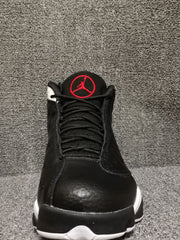Front view of black high-top sneakers with red tongue emblem and white outsole accents