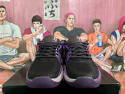 Front view of the black and purple Nike basketball sneakers, showing the black toe boxes, laces, and purple trim.