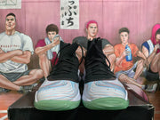 Front view of black lace-up high-top basketball shoes with multicolor patterned toes.