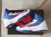 Two Nike high-top sneakers arranged on a shoebox with their blue-and-red outsoles visible.