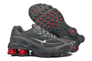 Gray Nike Shox Ride 2 sneakers shown from the side and outsole, highlighting the circular tread and red accents.