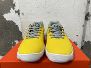 Front view of yellow Nike sneakers with gray laces and white soles