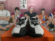 Front view of white and black Nike basketball sneakers with black laces, perforated toe panels, and contrasting black toe sections.