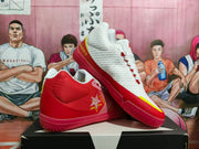 Angled view of the Converse sneakers highlighting the red side panels, white uppers, yellow accents, and star branding.