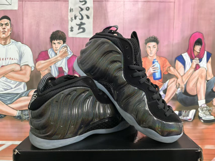 Pair of black Nike basketball sneakers with a reflective sculpted upper and translucent soles, displayed against an illustrated basketball backdrop.