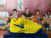 Close side view of a yellow Nike LeBron basketball shoe with textured upper and blue Swoosh.