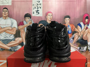 Rear view of black high-top sneakers with heel pull tabs and visible cushioning.