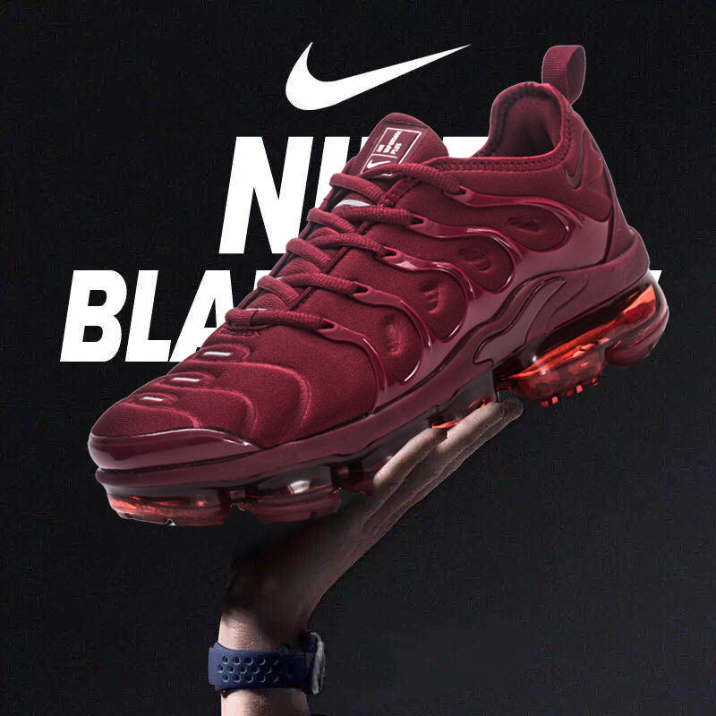 Burgundy Nike low-top sneakers with a translucent segmented sole, shown against a dark graphic background.