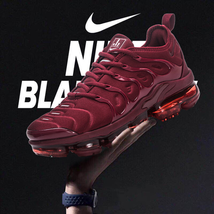 Burgundy Nike low-top sneakers with a translucent segmented sole, shown against a dark graphic background.