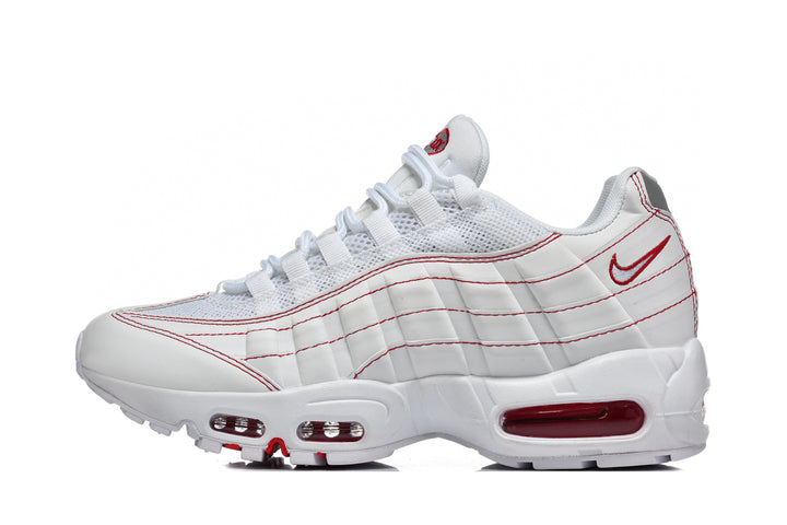 Side view of a white Nike Air Max 95-style sneaker with red accents, mesh upper, layered panels, and visible air-cushioning windows.