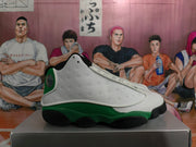 Side profile showing the white perforated upper, green lower panels, black outsole, and circular heel detail.