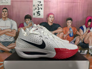 Side profile of a white Nike basketball sneaker with black Swoosh branding, perforated panels, red toe detail, and visible “ZOOMX” lettering.