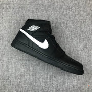 Angled top-side view of a black and white mid-top sneaker with visible collar branding.