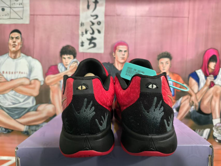 Rear view of red and black basketball sneakers showing black heel panels, red outsole accents, and textured heel graphics.