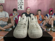 Front view of the white high-top sneakers showing the lace-up panels, tongues, and rounded textured toes.