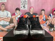 Front view of the silver Nike sneakers with black laces, black toe trim and orange accents.