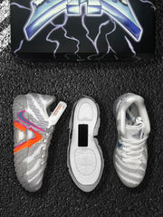Pair of grey and white basketball sneakers with orange and pink side details, shown with the outsole and box.