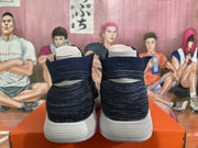 Rear view of navy high-top sneakers showing knit-patterned collars and white soles.