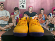 Front view of yellow Nike basketball shoes with purple toe accents and laces