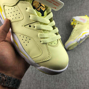 Close-up of the toe and lacing area showing perforated panels, stitched overlays, and a pale yellow finish.