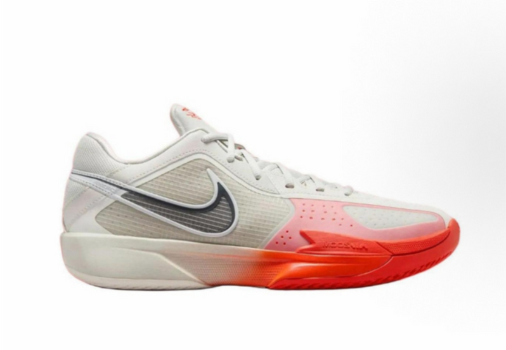 Side view of beige and red Nike basketball sneakers with a contrasting Swoosh, lace-up closure, perforated forefoot panel, and textured outsole.