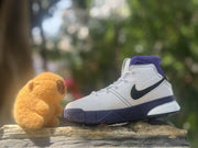 Side profile showing the white textured upper, black Swoosh and purple midsole accents