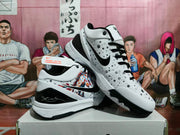 Angled view showing the black Swoosh, black laces, speckled white upper, and graphic side panel.