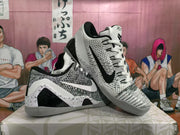 Angled display of both sneakers showing the contrasting Swoosh colors, woven uppers, speckled overlays, and low-top shape.