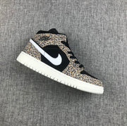 Side view of a leopard-print and black Air Jordan mid-top sneaker with a white Swoosh and white outsole.