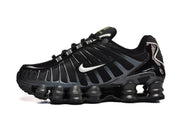Side view of a black Nike Shox TL sneaker with a white Swoosh and segmented sole.