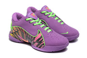 Angled view of the purple and green sneaker pair with perforated toes, bright green laces, and multicolor side panels.