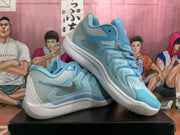 Angled view of the pair of ice blue Nike basketball sneakers displayed on a black shoebox.