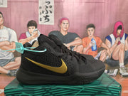 Side view of a black basketball sneaker with a gold Nike Swoosh, textured upper, and patterned outsole.