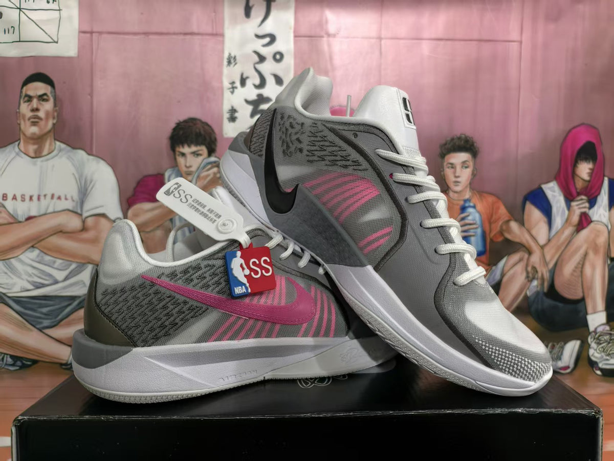 Pair of white, gray, and pink Nike basketball-style sneakers displayed on a black box.