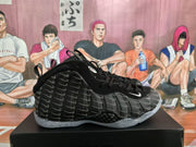 Side view of a black Nike basketball sneaker with repeating gray Swoosh graphics and a translucent speckled sole.