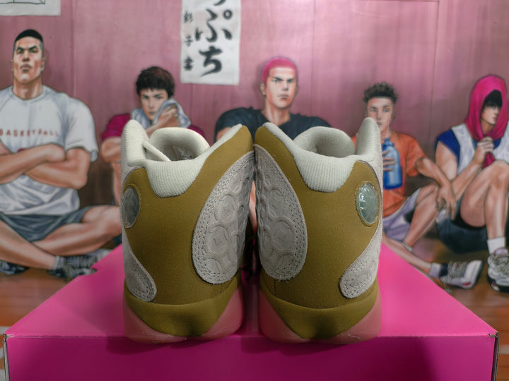 Rear view of olive and cream Jordan sneakers with circular heel accents and pink translucent soles on a box.